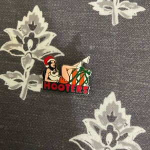 Hooters Christmas pin girl lounging on gifts 00s era novelty collectible holiday
